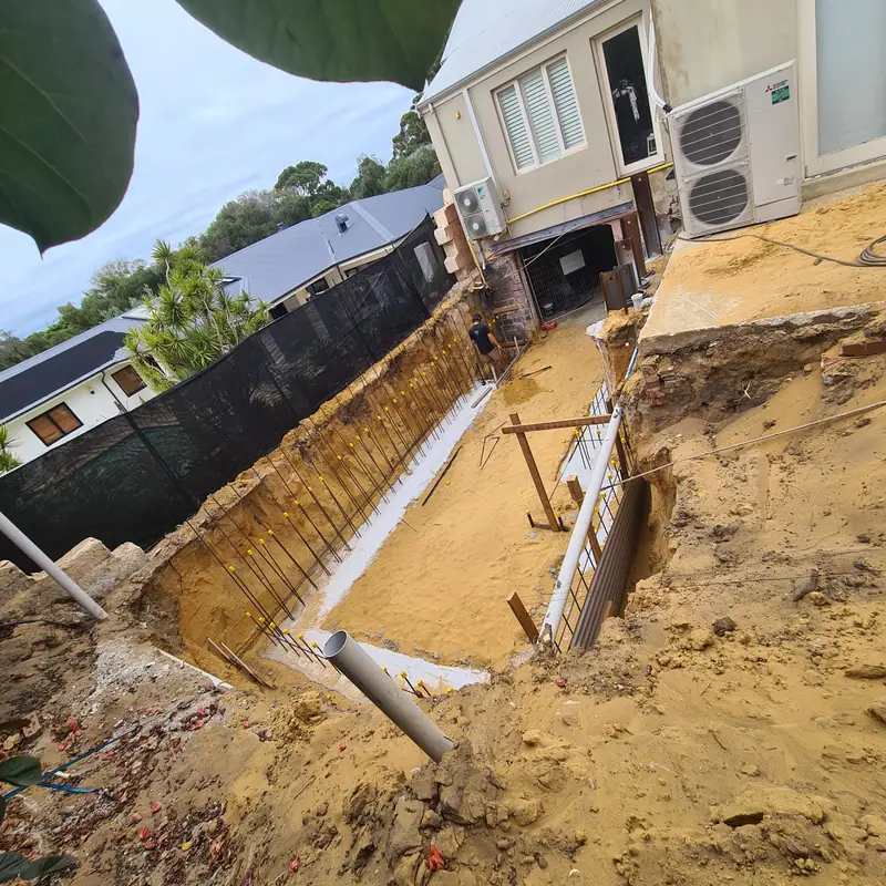 Excavation beside a home, with stabilised sand walls and formwork in the base